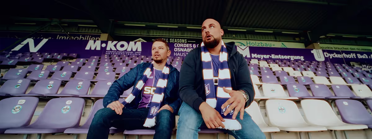 Zwei Männer in einem Stadion auf Sitzplätzen